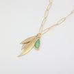 Handmade brass layered leaf and resin stone charm necklace, close-up detail on white background
