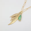 Handmade brass charm necklace with sculptural leaf pendants and resin stone on paperclip chain
