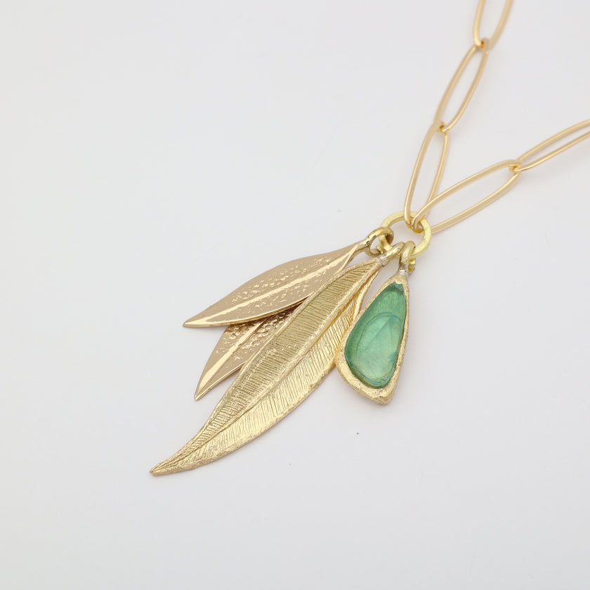 Handmade brass charm necklace with sculptural leaf pendants and resin stone on paperclip chain
