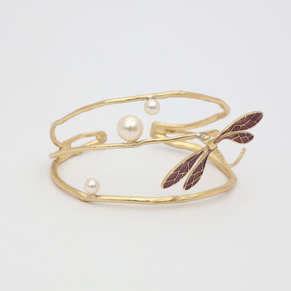 Gold bracelet with pearl beads and leaf design on a white background