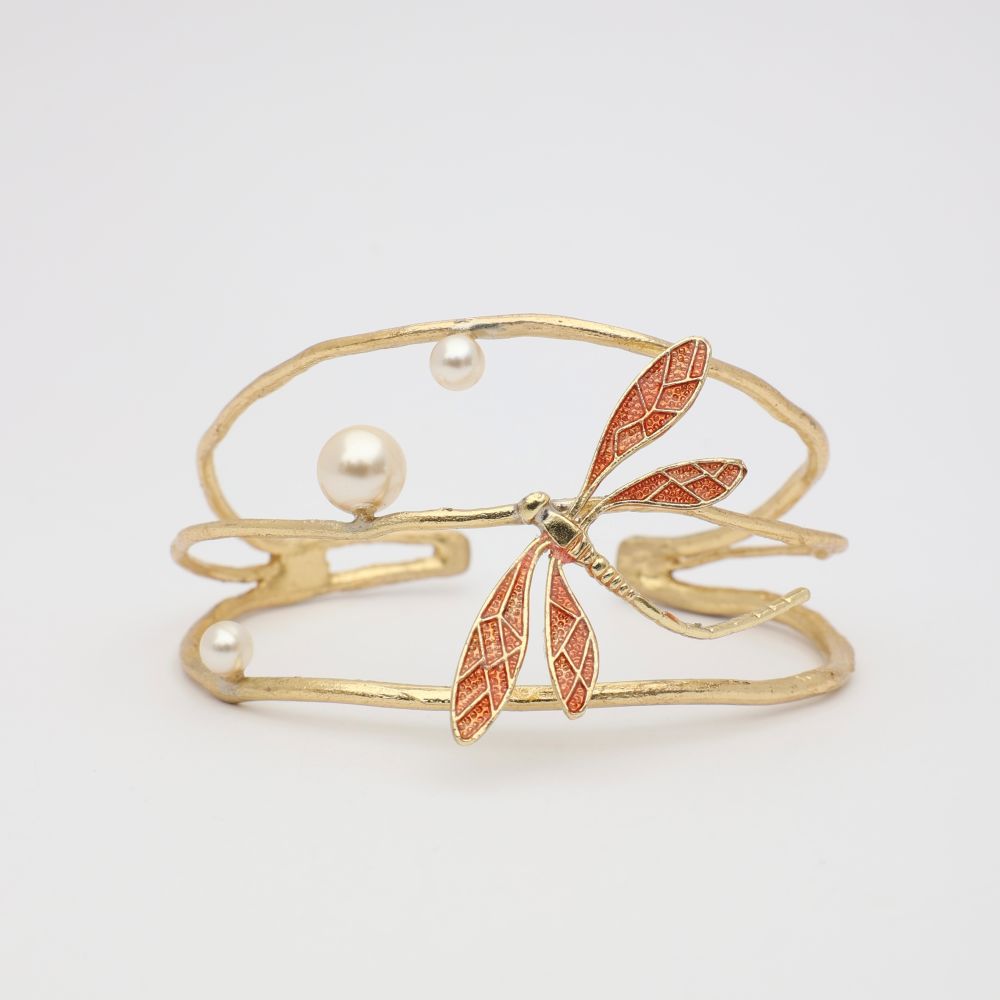 Gold bracelet with dragonfly and pearl design on a light gray background