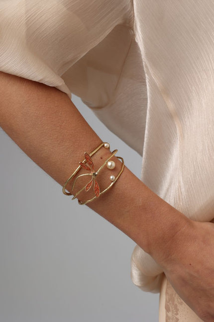 Buzz Bracelet — handmade brass dragonfly cuff bracelet with enamel wings and freshwater pearls, worn on model