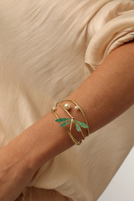 Buzz Bracelet on model — artisan brass multi-wire cuff with enamel dragonfly and pearl accents