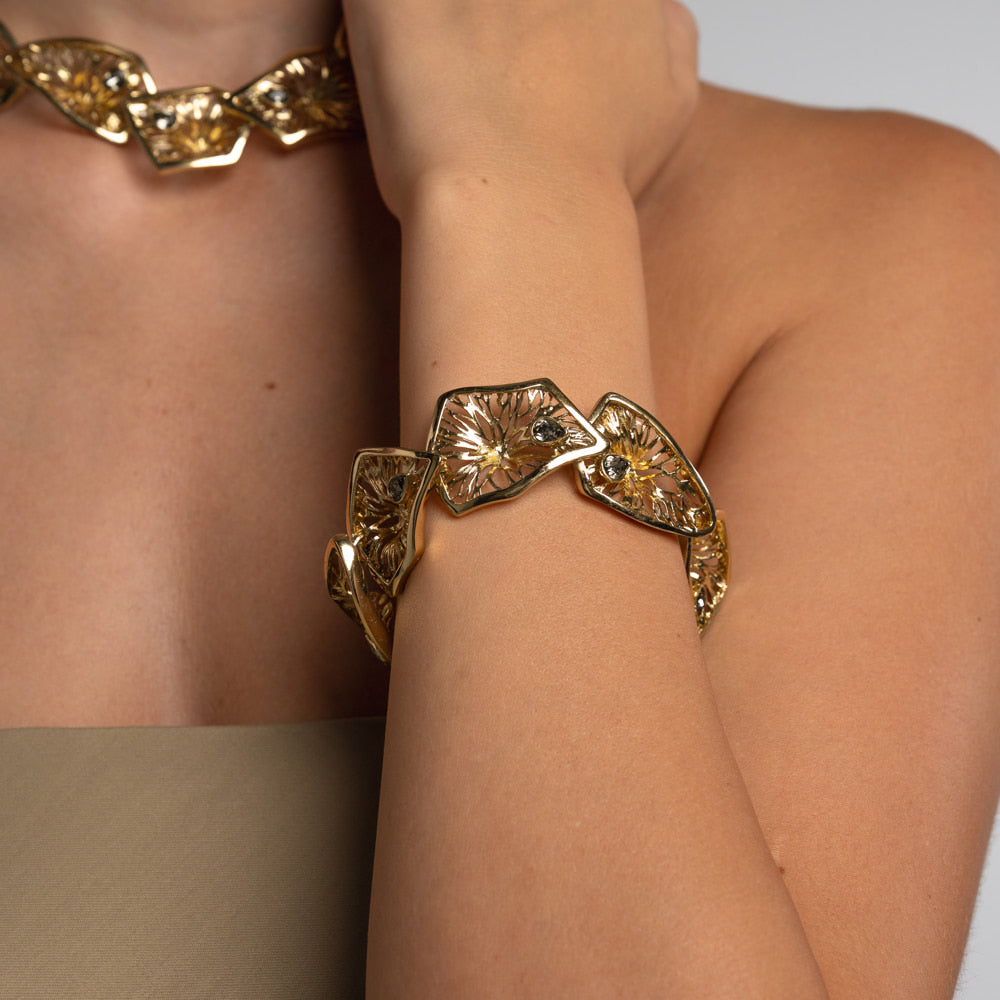 Canopy Bracelet — handmade brass statement bracelet with etched panels and teardrop gemstones, worn on model