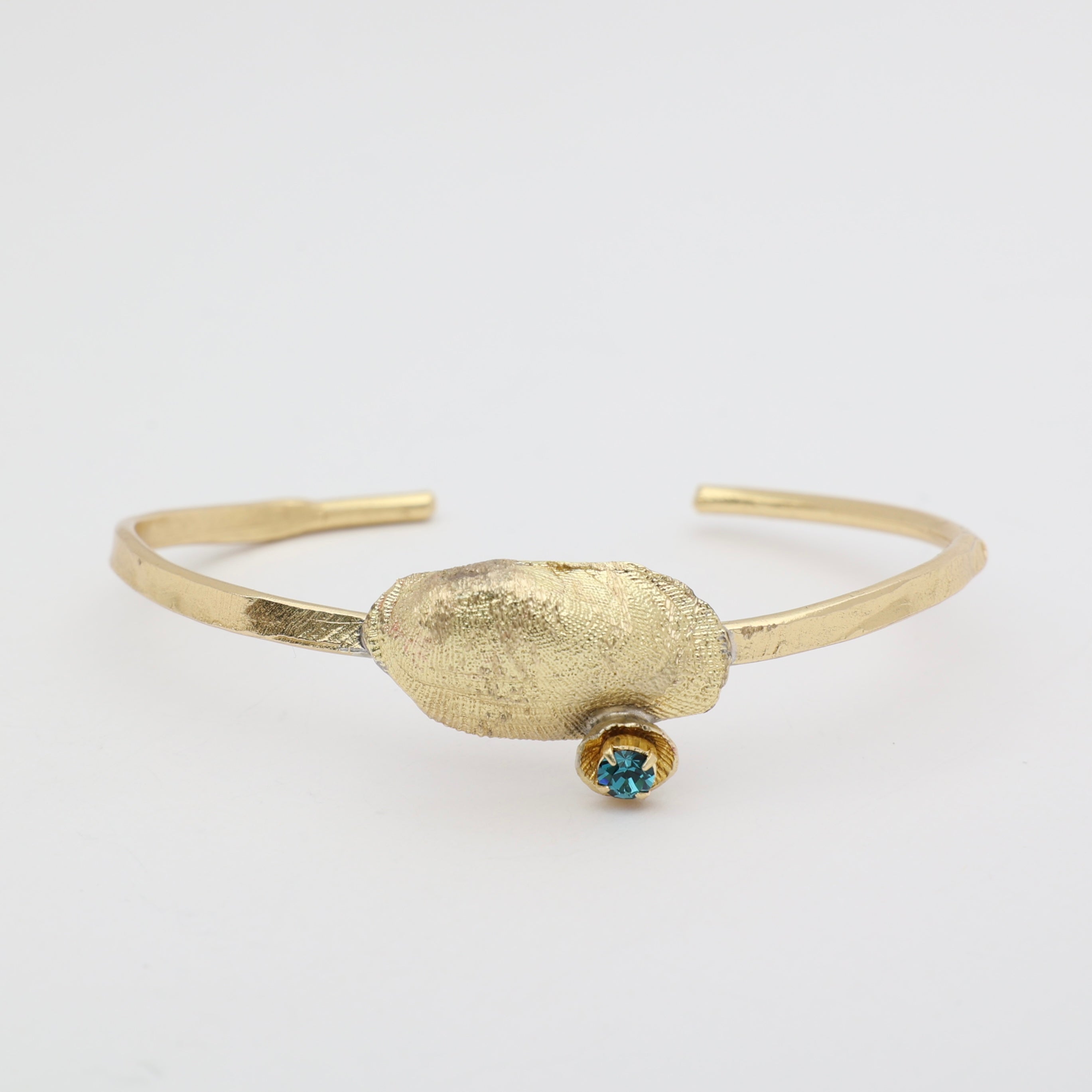 Limpet Bracelet close-up — handmade brass sculptural shell cuff with crystal 
