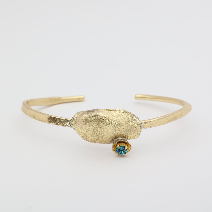 Limpet Bracelet close-up — handmade brass sculptural shell cuff with crystal 
