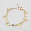 Handmade brass sculptural leaf bracelet with crystal accent on white background
