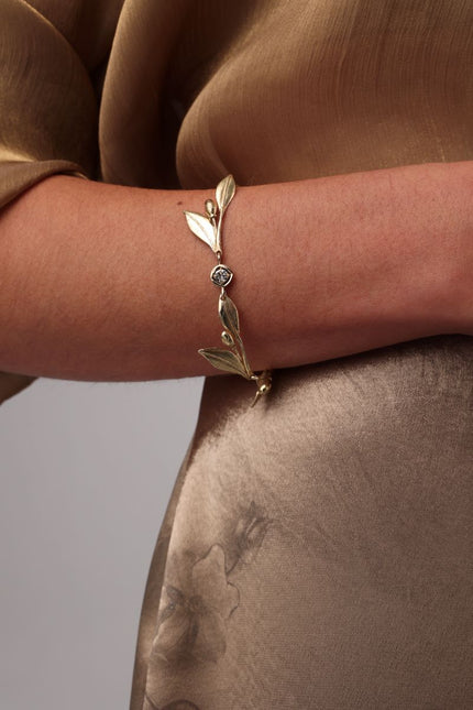 Handmade brass nature-inspired bracelet with leaf and fruit motifs, close-up detail
