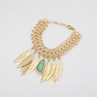 Handmade brass chainmail bracelet with sculptural leaf charms and resin stone on white background
