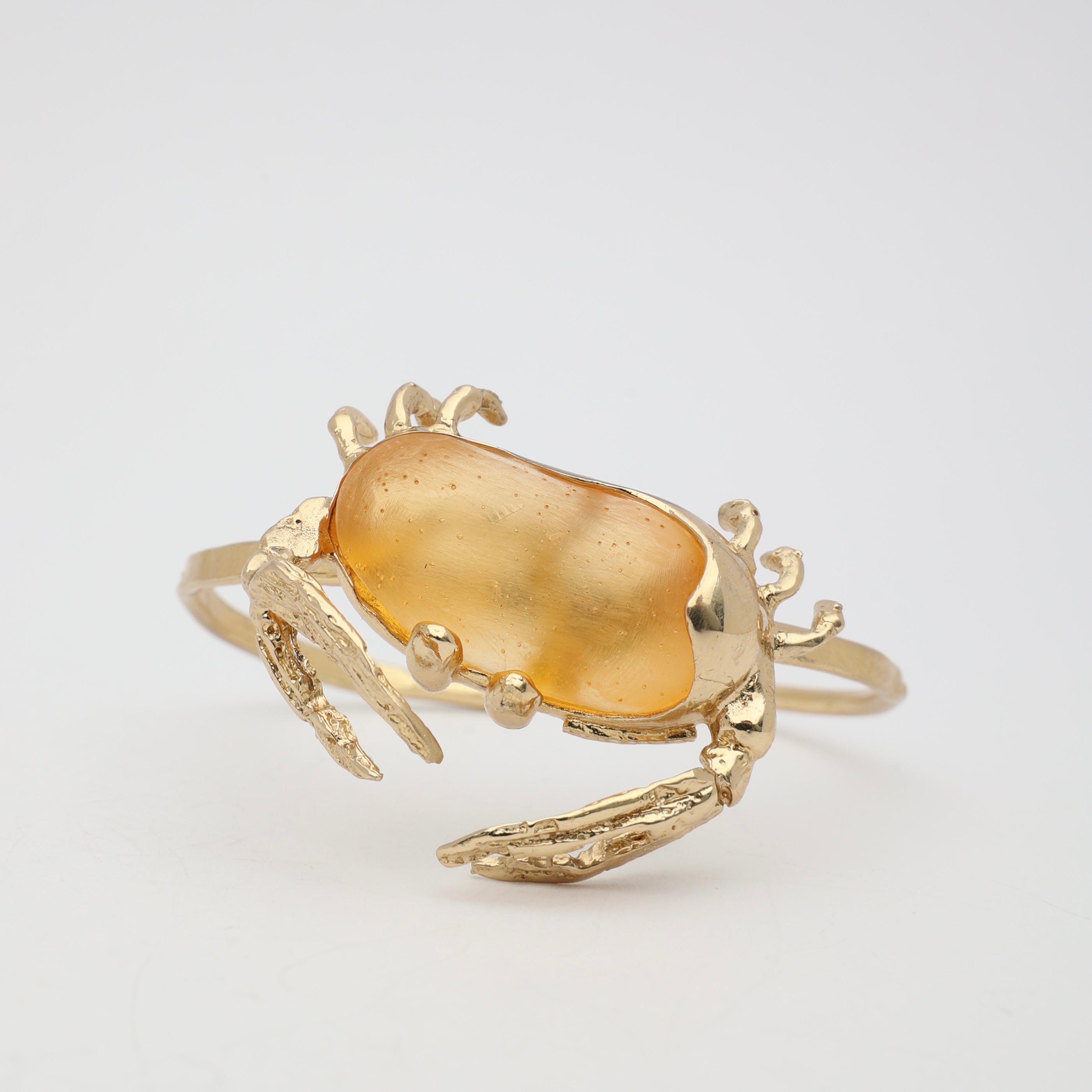 Crabby Bracelet on background — handmade brass artisan cuff bracelet with nature-inspired crab sculpture
