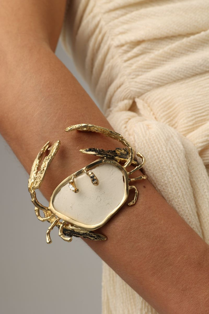 Crasta Bracelet close-up — handmade brass open cuff with textured crab legs and organic resin stone centerpiece
