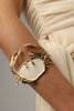 Crasta Bracelet close-up — handmade brass open cuff with textured crab legs and organic resin stone centerpiece
