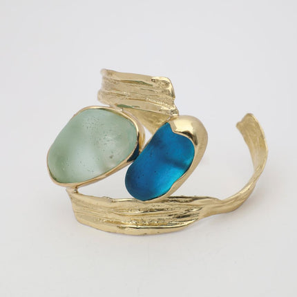 handmade brass textured cuff bracelet with two freeform gemstones, flat lay view, artisan jewelry made in Greece