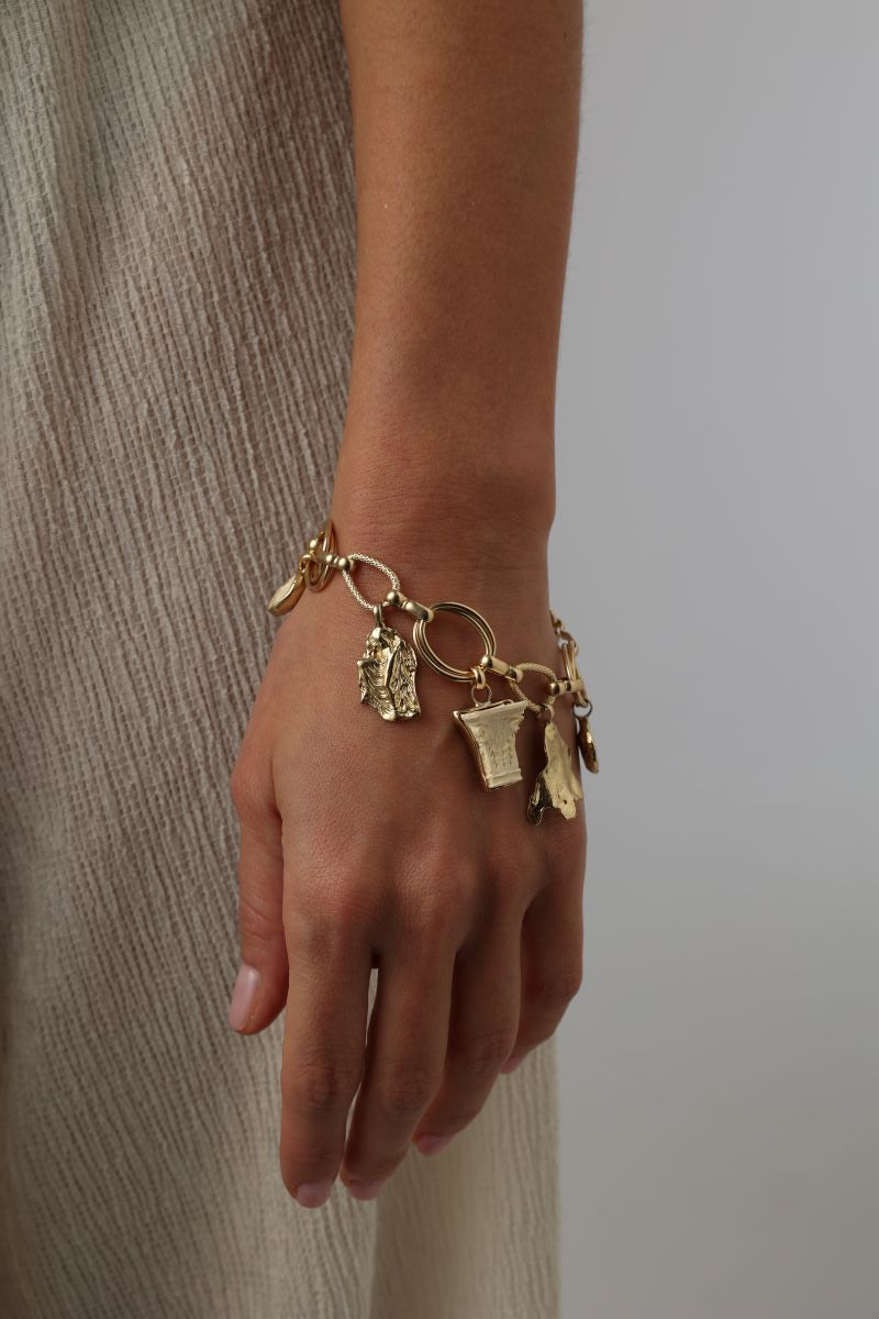 Icon Bracelet — handmade brass Greek mythology charm bracelet with ancient symbols worn on model