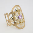 Product shot of a gold brass filigree cuff bracelet on a white background.