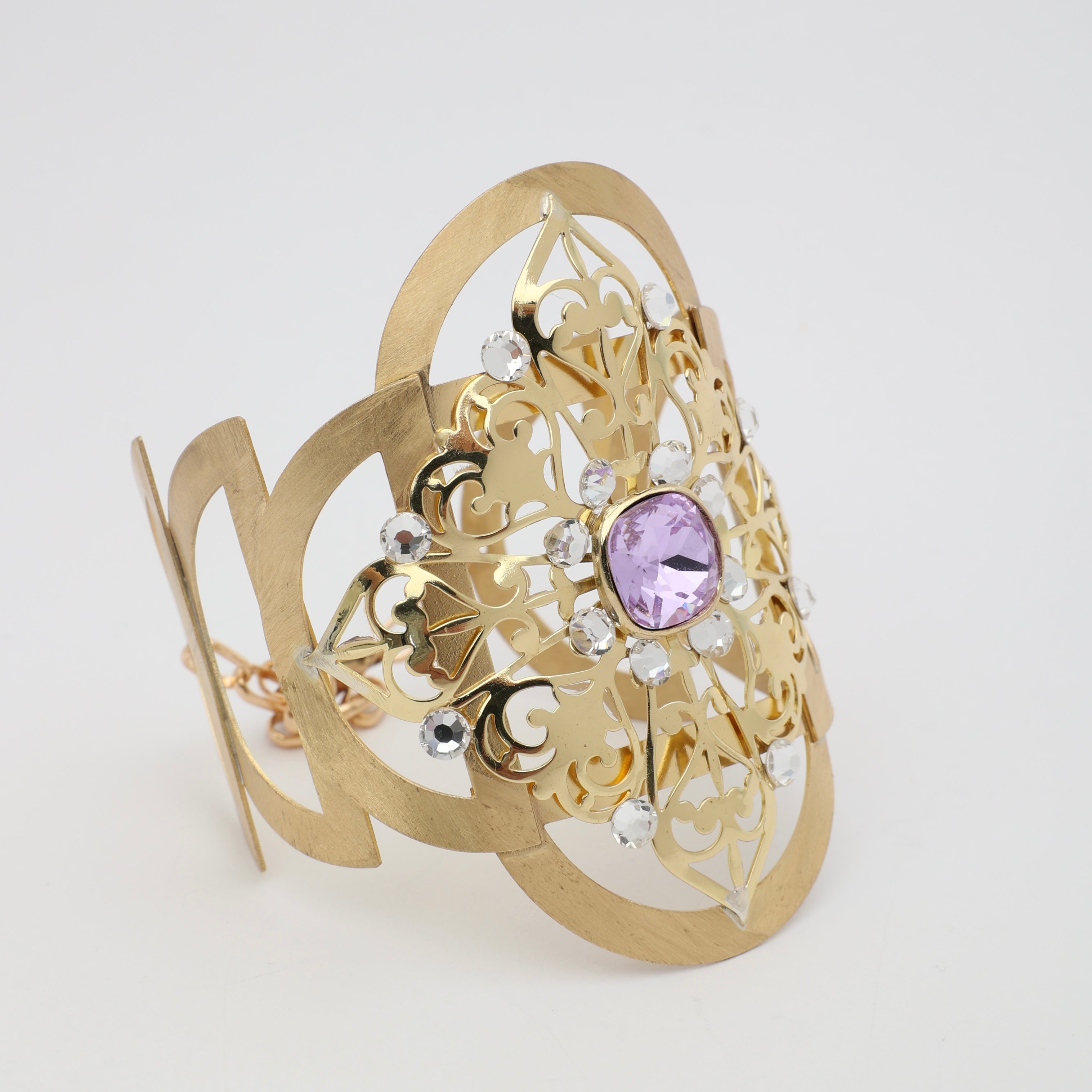 Product shot of a gold brass filigree cuff bracelet on a white background.