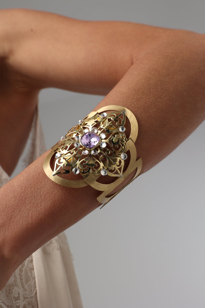 Model showing off a handmade brass cuff bracelet on her forearm.