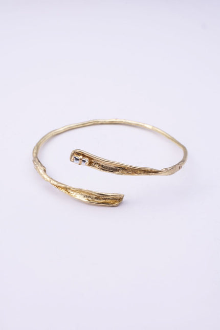 Glade gold wrap cuff bracelet with organic branch texture and clear baguette-cut crystal on a white background