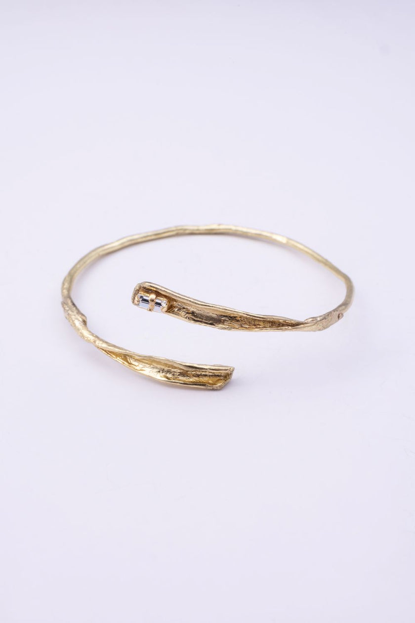Glade gold wrap cuff bracelet with organic branch texture and clear baguette-cut crystal on a white background