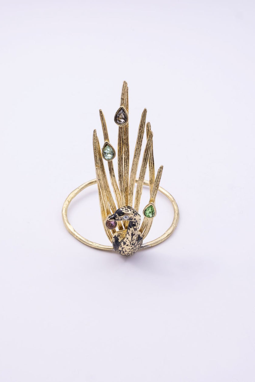 Gold peacock cuff bracelet with black oxidized bird and multicolor pastel crystals, front view on white background