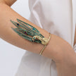 Woman wearing the Peacock cuff bracelet with green patina feathers and blue, purple and turquoise teardrop crystals,