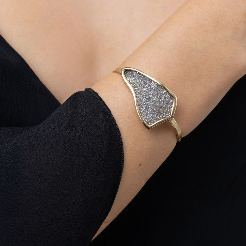 Woman wearing the Edge gold-plated cuff bracelet with a silver crystal-encrusted plate, Glitter Kiss