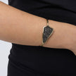 Woman wearing the Edge gold-plated cuff bracelet with a dark hematite crystal-encrusted plate, Glitter Kiss