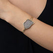 Gold cuff bracelet with sparkling crystal panel worn on the wrist