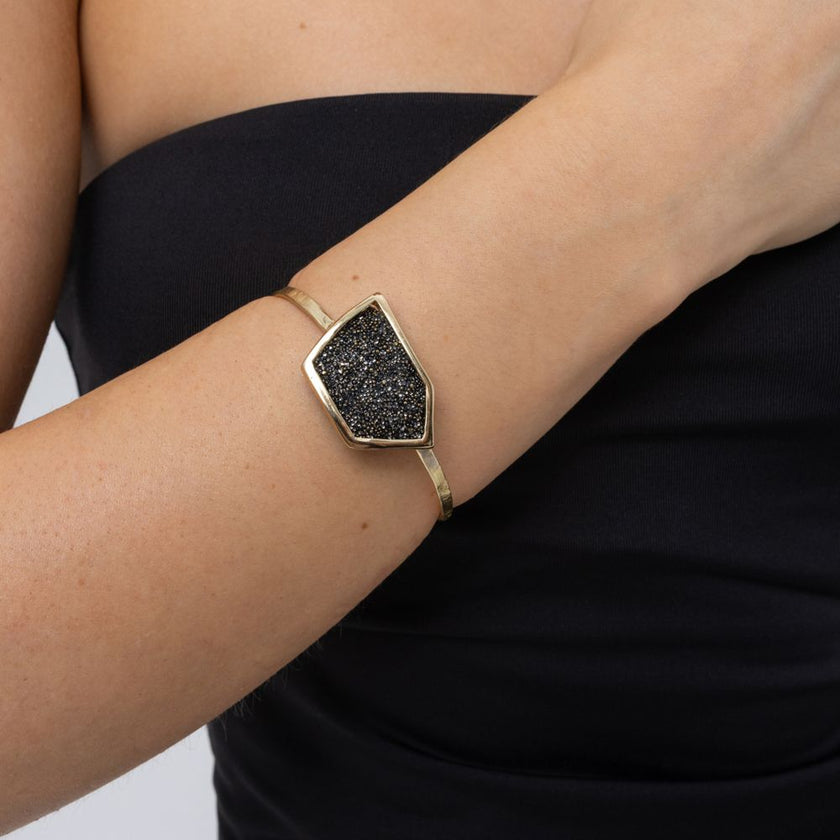 Woman wearing handmade gold cuff bracelet with geometric crystal panel, Glitter Kiss collection