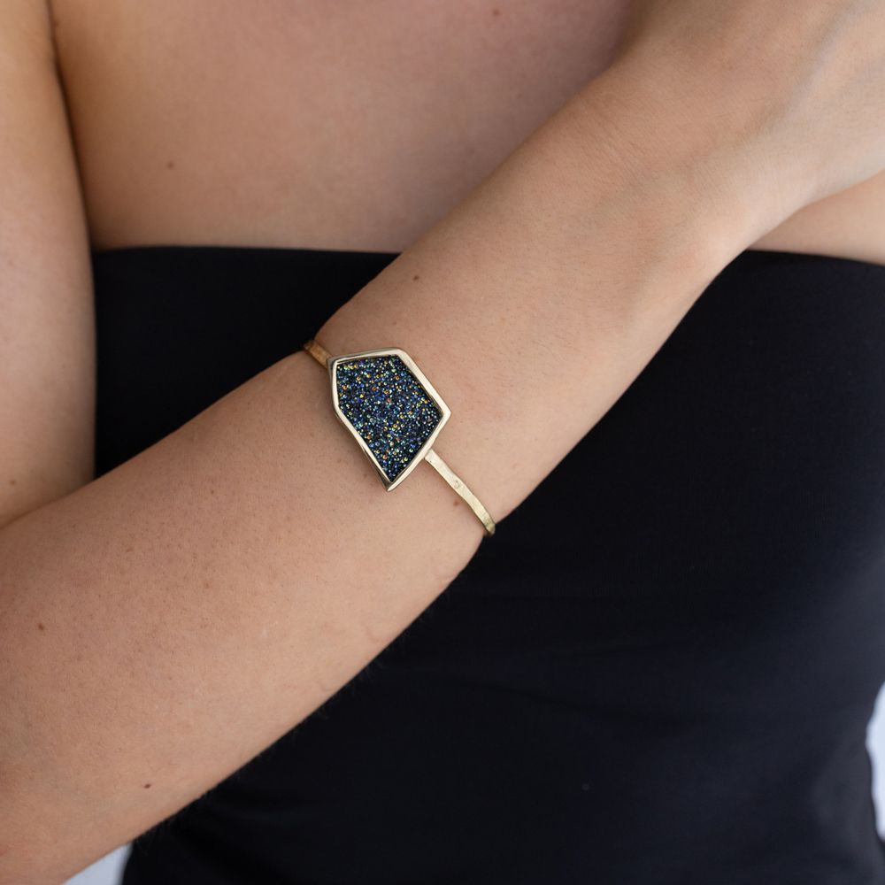 Handmade gold cuff with sculptural geometric crystal panel worn on the wrist