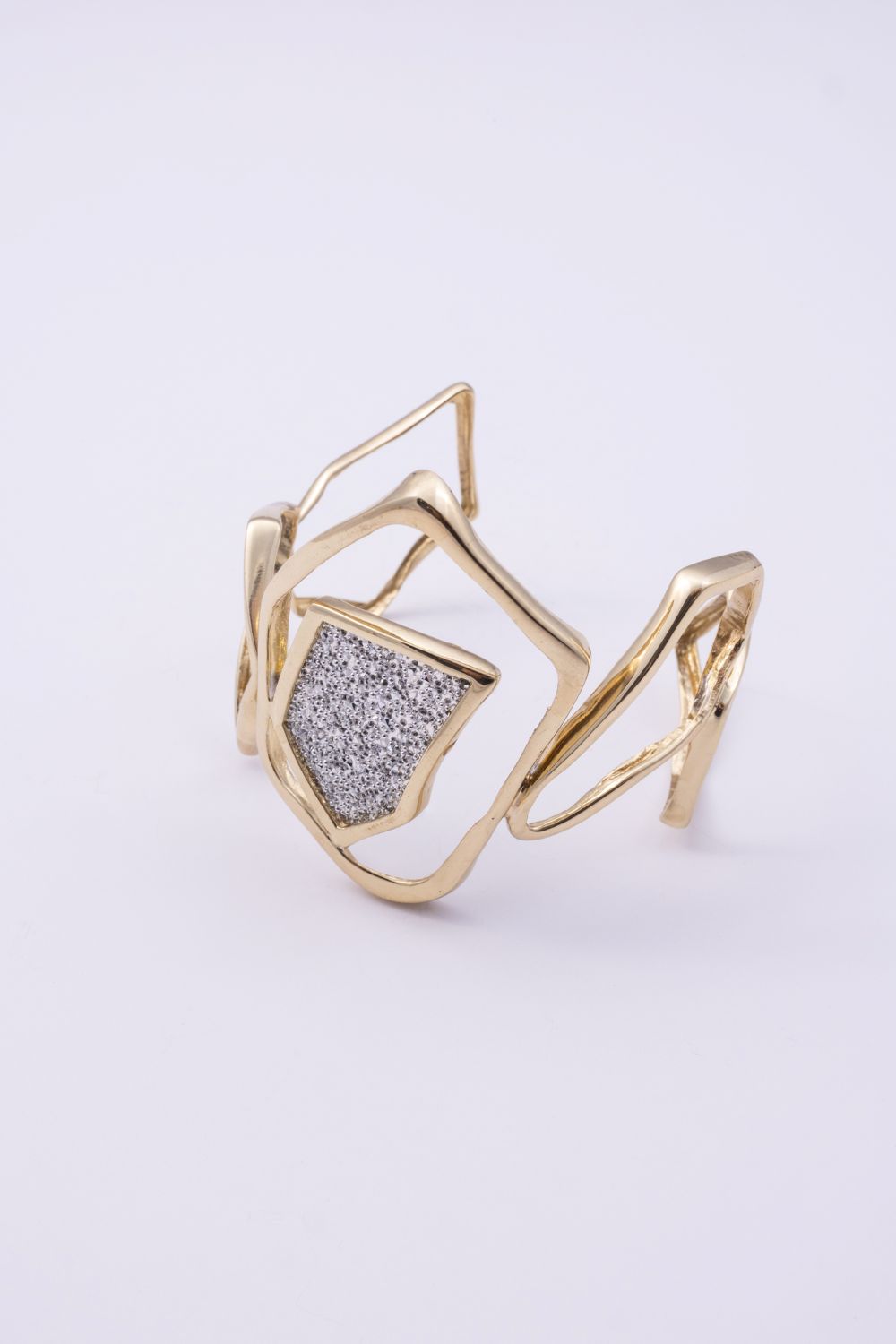 Glow cuff bracelet with sculptural gold lines and crystal centre