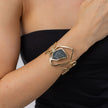Wide gold statement cuff bracelet with crystal centre worn on the wrist