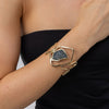 Wide gold statement cuff bracelet with crystal centre worn on the wrist