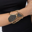 Woman wearing handmade wide gold cuff with organic loops and two crystal panels, Glitter Kiss collection