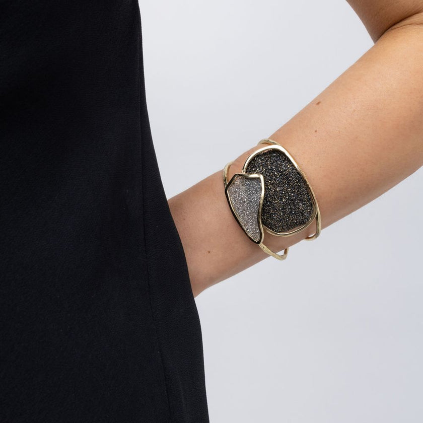 Woman wearing handmade gold cuff bracelet with two overlapping crystal panels, hand on hip