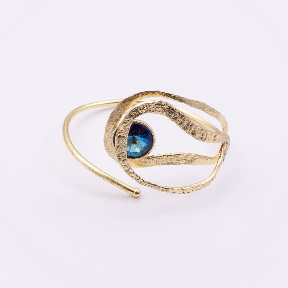 Boteh gold wrap cuff bracelet with textured leaf-like loops and iridescent blue crystal, angled view on white background