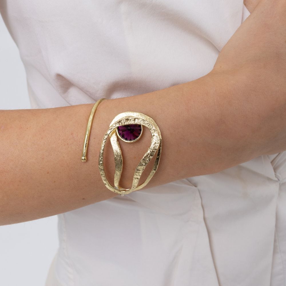Woman wearing the Boteh gold wrap cuff bracelet with organic textured loops and a purple amethyst-colored crystal, Savage Flora