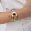 Woman wearing the Boteh gold wrap cuff bracelet with organic textured loops and a purple amethyst-colored crystal, Savage Flora