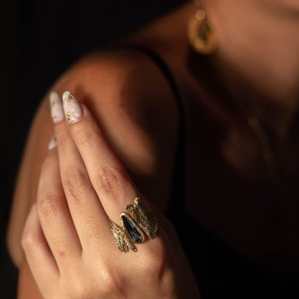 rtisan gold-tone brass organic textured statement ring with blue teardrop crystal stone worn on hand — Bell Ring by Kalliope Jewelry, crafted in Greece