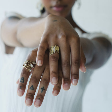 Handmade gold-tone brass wide band textured ring with embedded white marquise crystal worn on hand — Bell Ring by Kalliope Jewelry, crafted in Greece