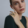 Handmade gold-tone brass sculptural cocktail ring with large marquise grey crystal and layered petal design worn on hand — Dazzle Ring by Kalliope Jewelry, crafted in Greece