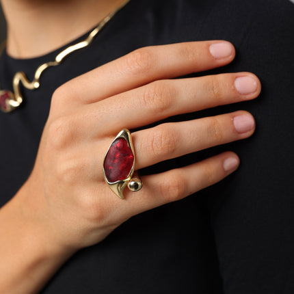 Handmade gold-tone brass statement ring with smooth resin eye-shaped centerpiece and textured bead detail worn on hand — Cocoon Ring by Kalliope Jewelry, crafted in Greece