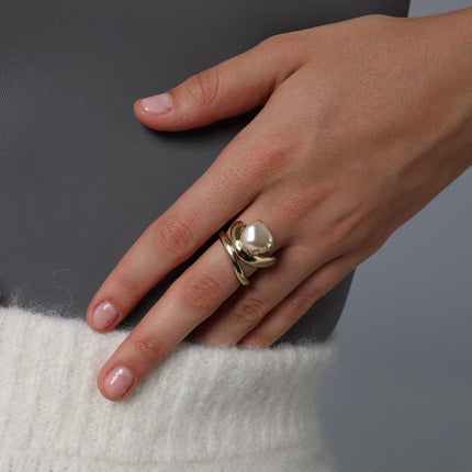 Artisan gold-tone brass layered statement ring with large baroque pearl worn against white knit — Swirl Layered Ring by Kalliope Jewelry, crafted in Greece