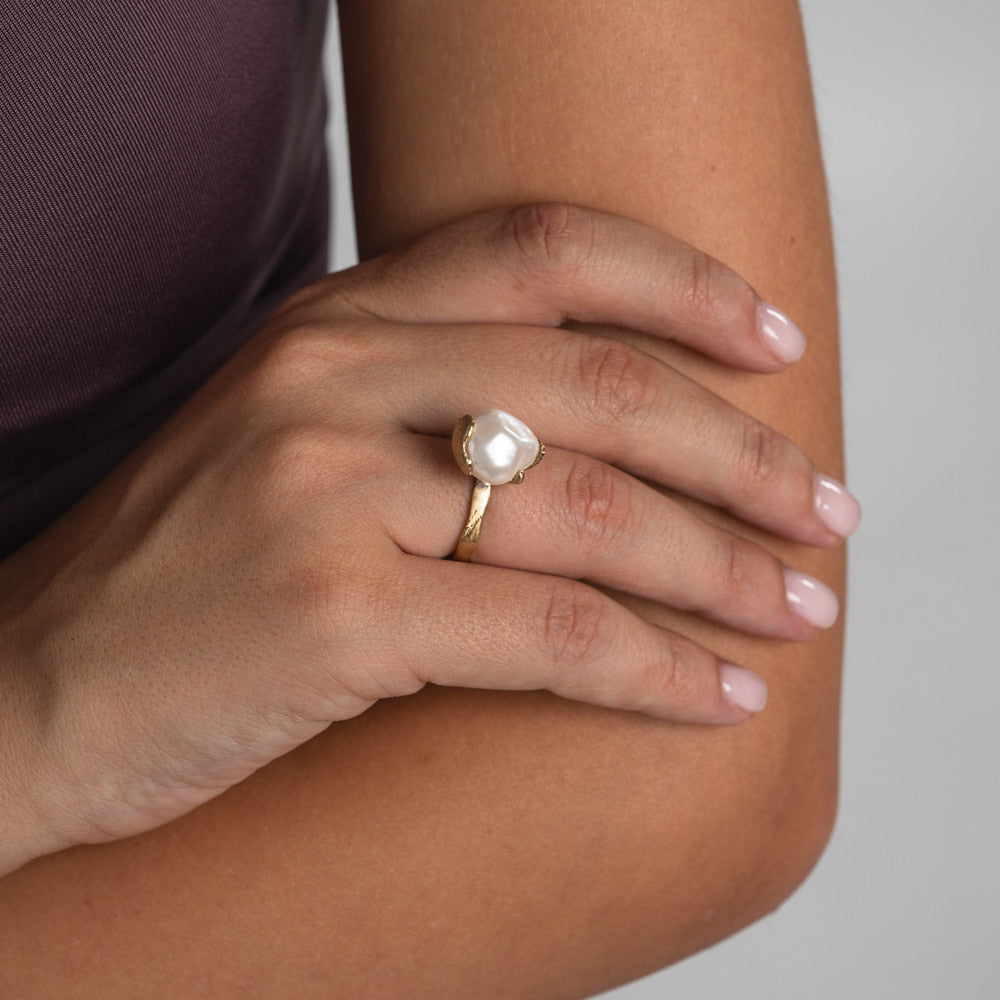 Handmade gold-tone brass ring with large baroque pearl stone worn on hand — Swoon Ring by Kalliope Jewelry, crafted in Greece