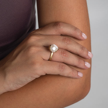 Handmade gold-tone brass ring with large baroque pearl stone worn on hand — Swoon Ring by Kalliope Jewelry, crafted in Greece