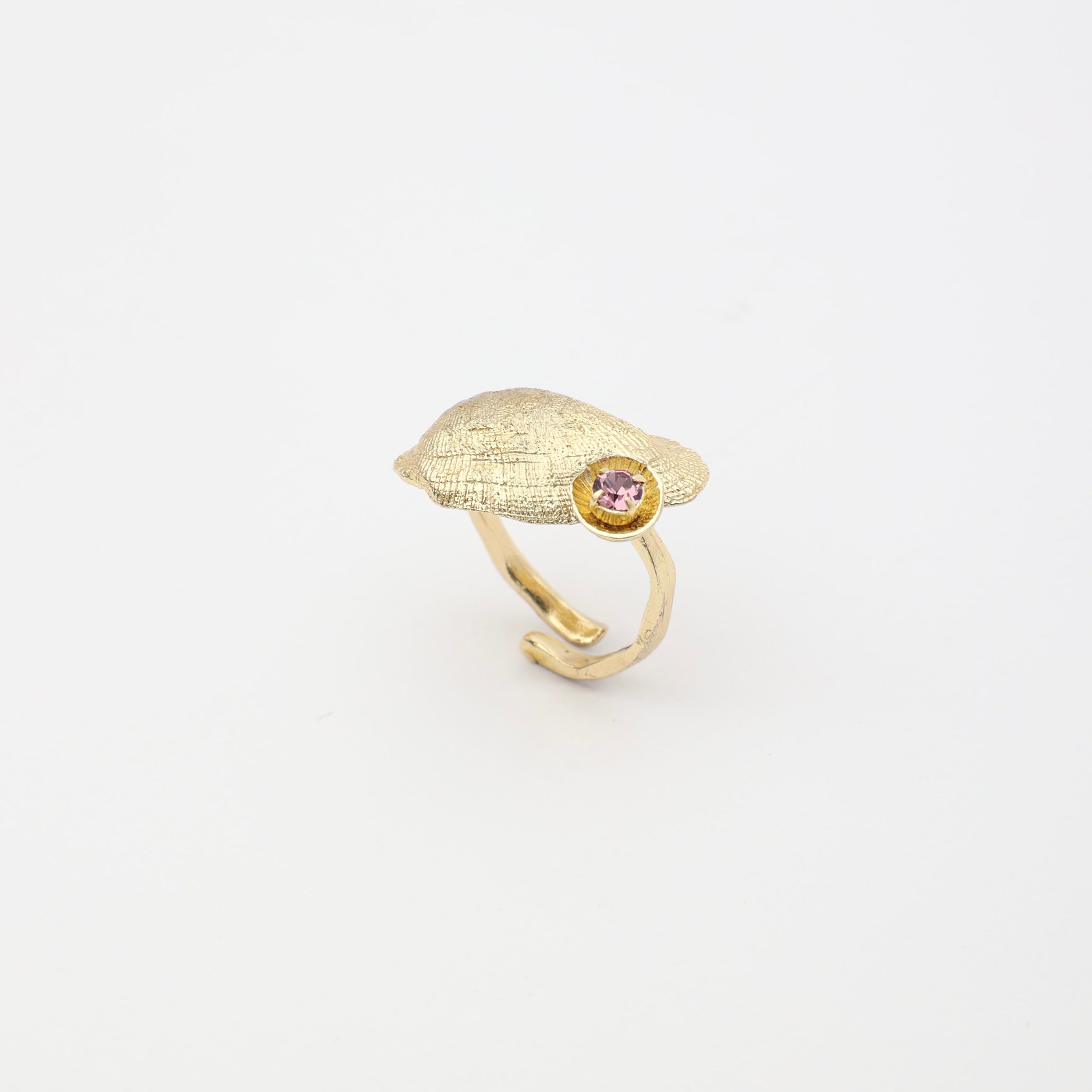 Limpet Ring — handmade brass adjustable ring with textured shell disc and gemstone detail on white background