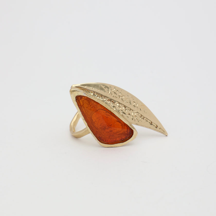 Handmade brass statement ring with resin stone on white background
