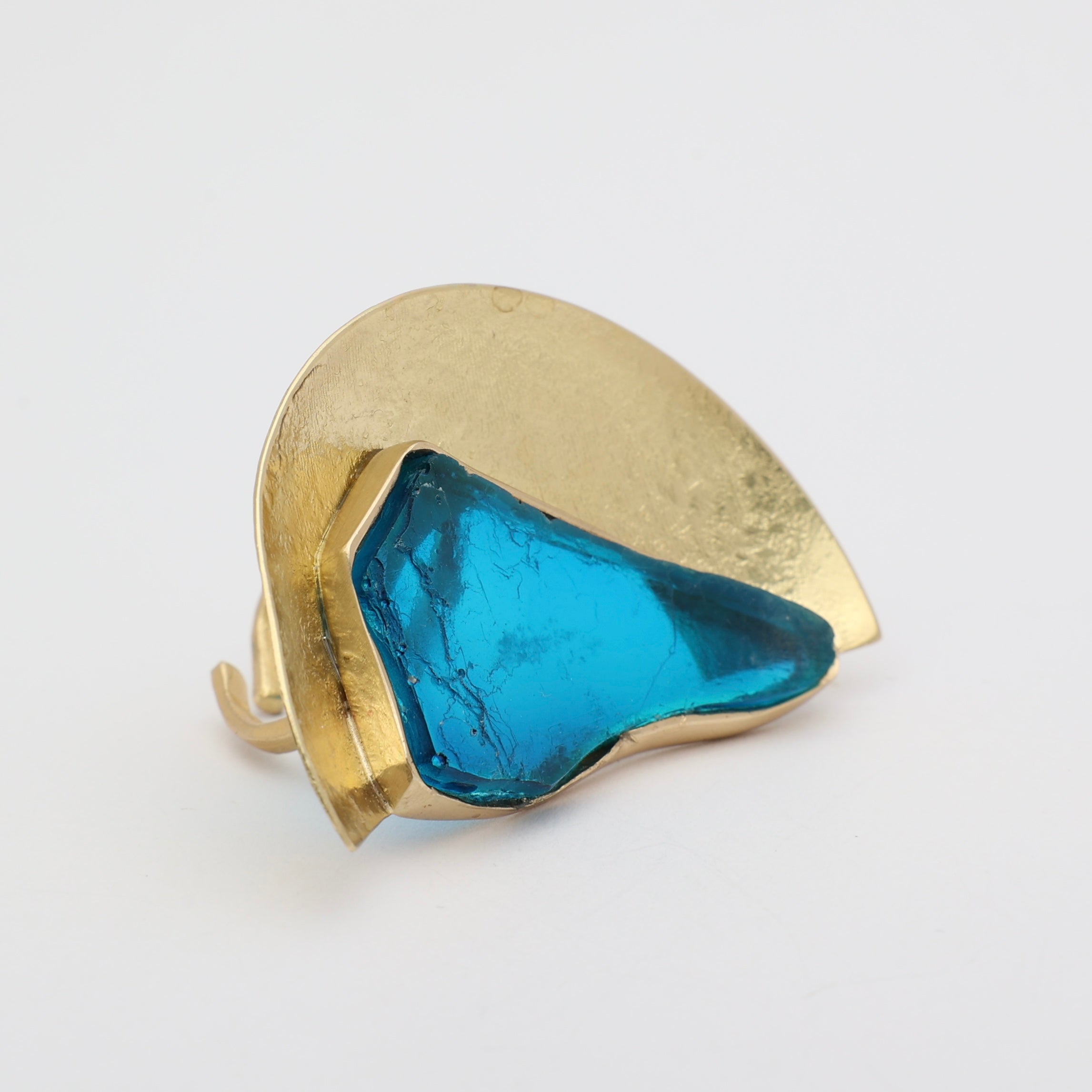 Pond Ring close-up — handmade brass ring with irregular raw resin stone set into wide brass shield
