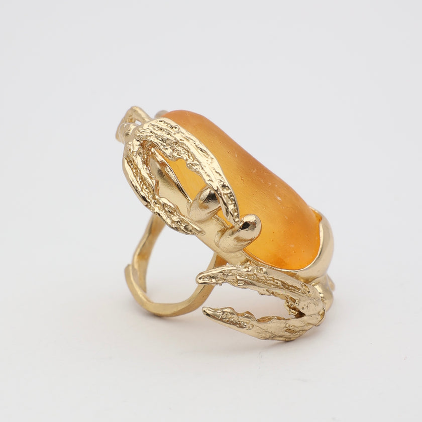 Crabby Ring — handmade brass statement ring shaped like a crab with resin stone body on white background