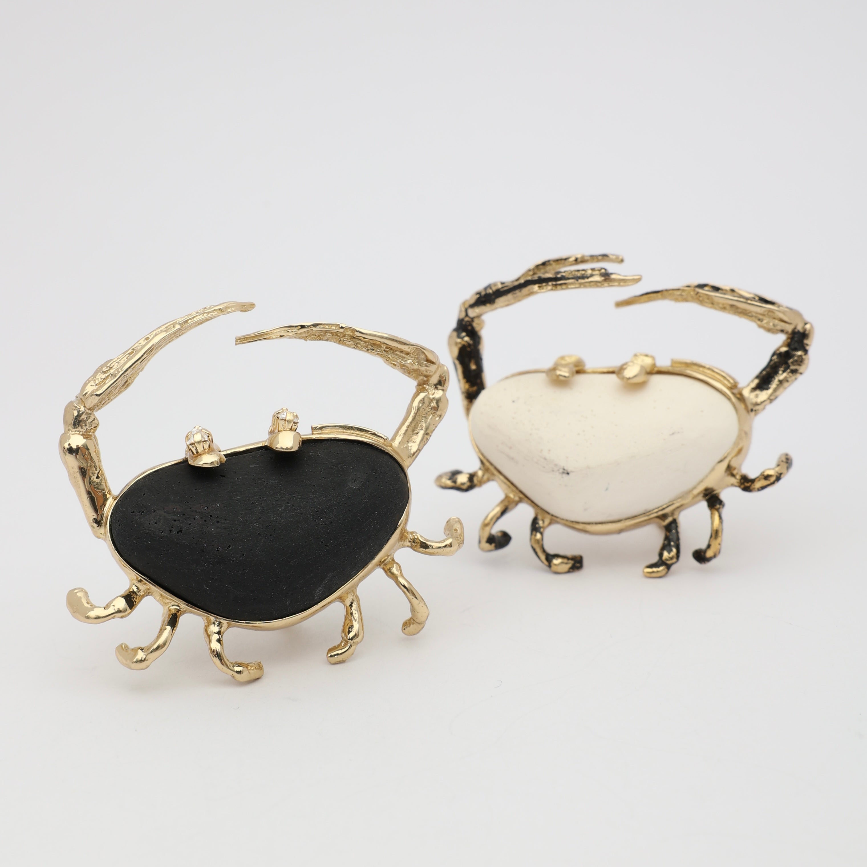 Claw Crabby Ring flat lay — handmade brass sculptural crab ring with wide resin stone centerpiece and crystal accents